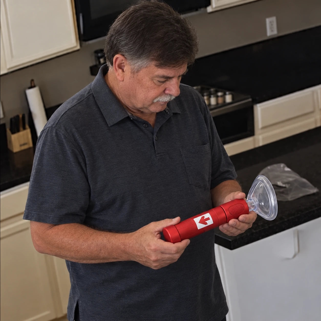 Older man reading the RescUAid instructions in his kitchen